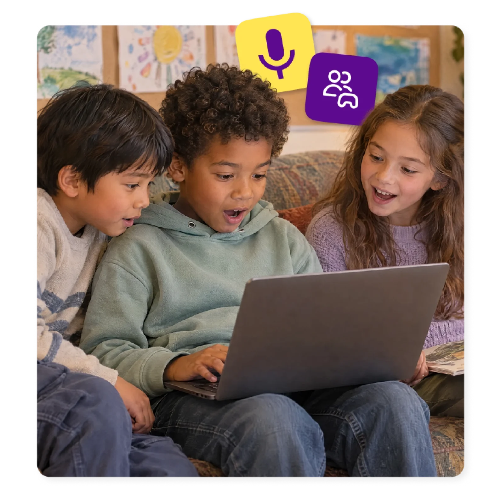 Three young students react together to a laptop screen in a shared collaborative learning space.