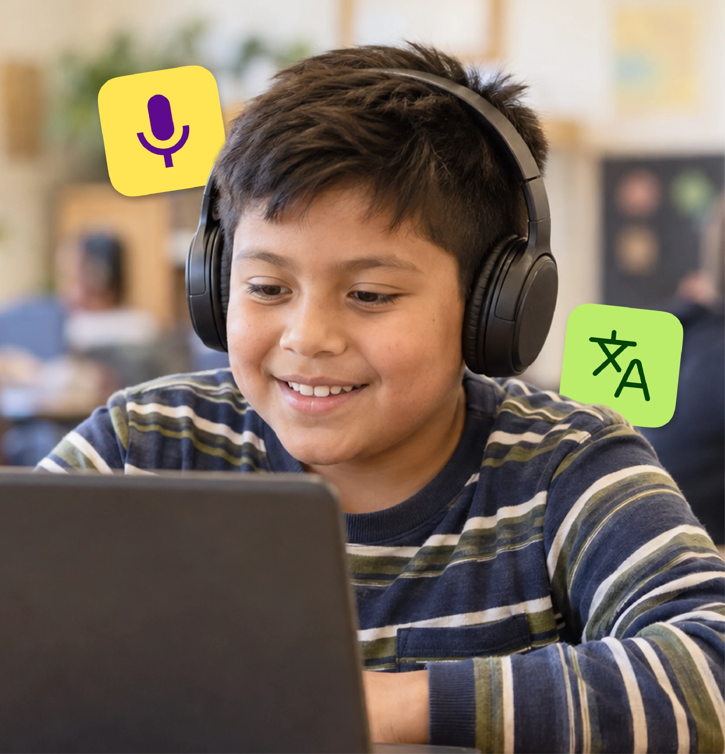 An elementary student smiles as he works on a laptop.