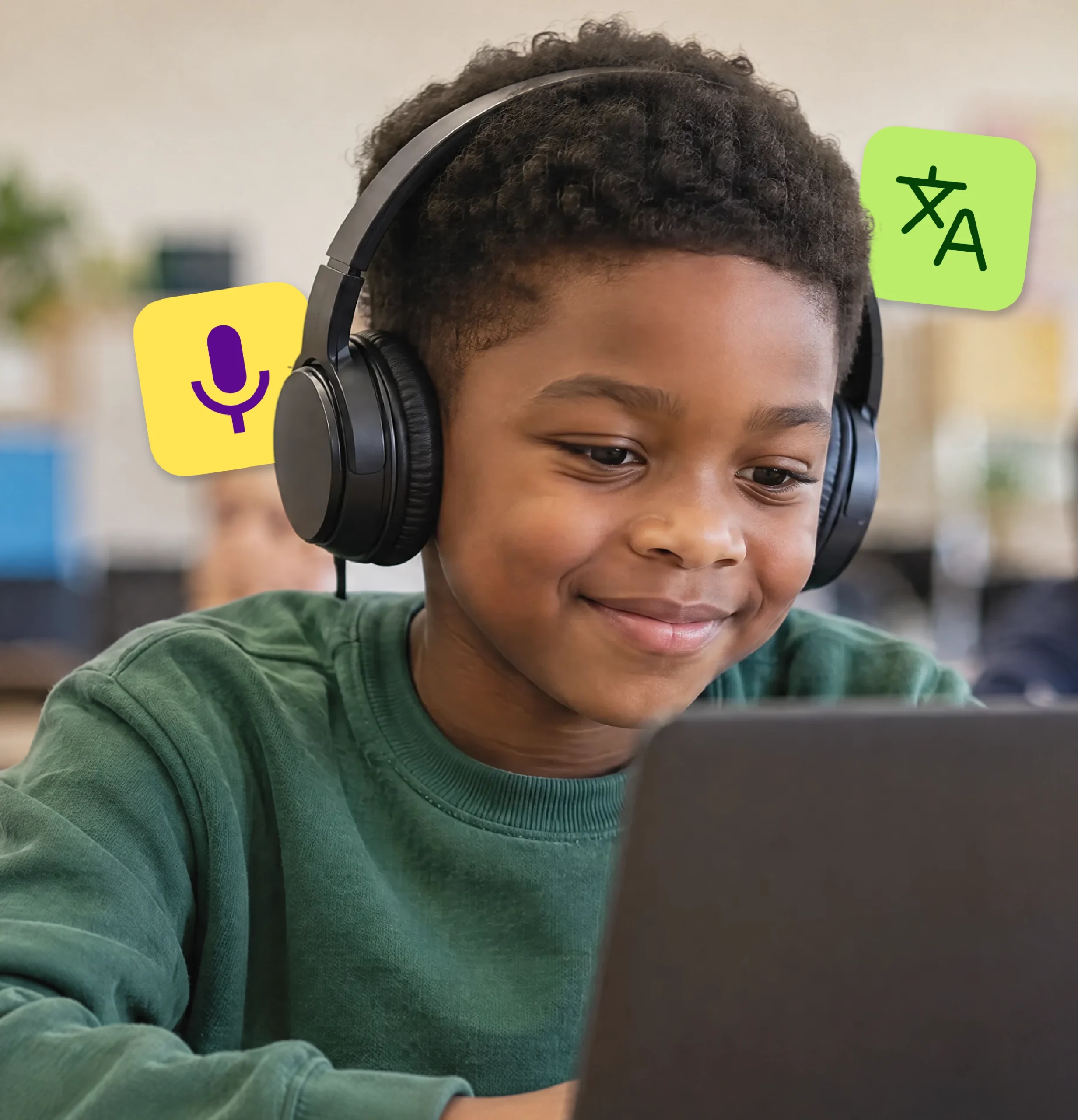An elementary student in headphones smiles while working on a laptop.