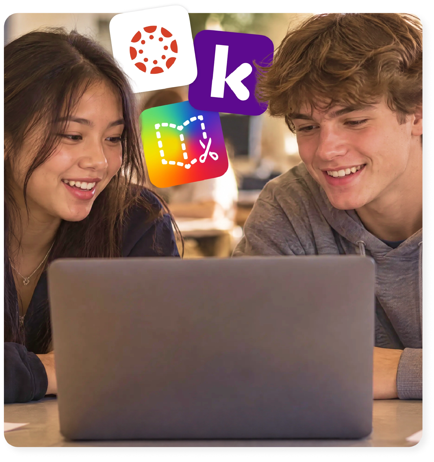 Two students work together on a laptop using the Kami App and Book Creator Canvas LMS integrations.