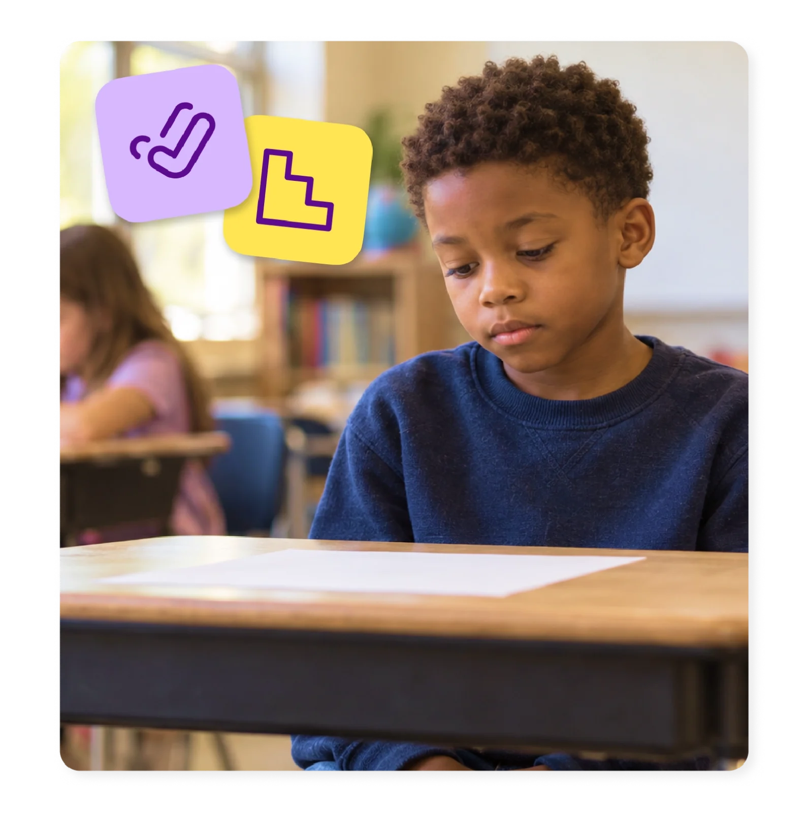 An elementary student sits at his desk looking unsure at a blank worksheet.