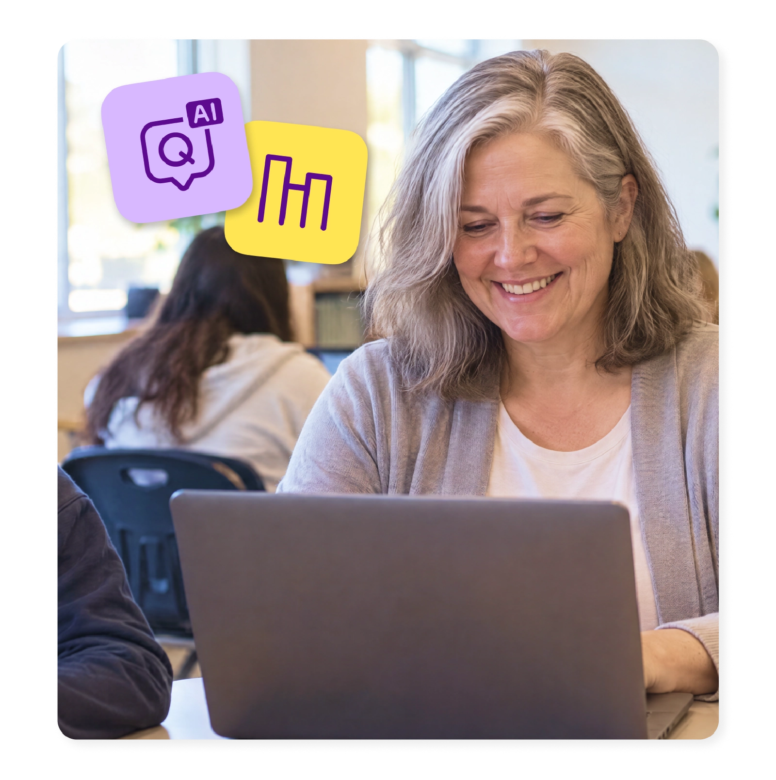 A teacher smiles at her laptop as her middle school class works around her.